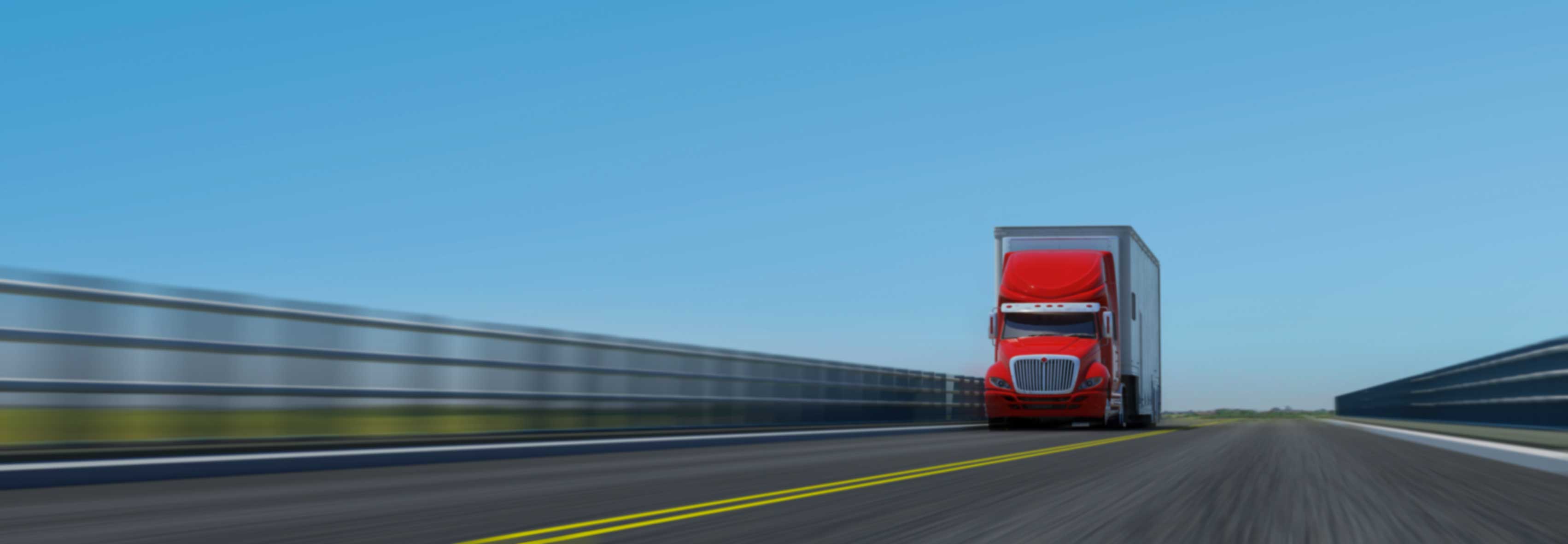 red semi truck hauling goods overland passing a fence that blurs in the picture 2023